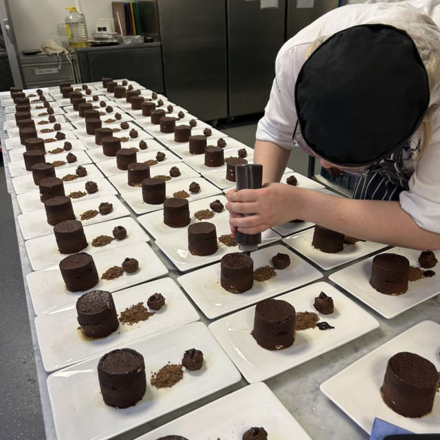 chef preparing rows of desserts