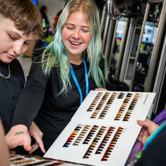 Hairdressing students looking at colour chart