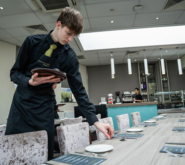 A student laying the table at The Wharncliffe