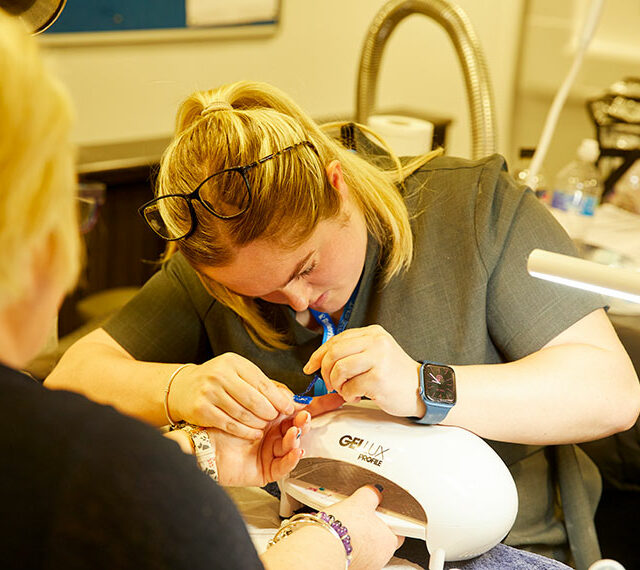A student working on a client's nails