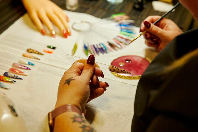 A close up of a student working at the nail bar
