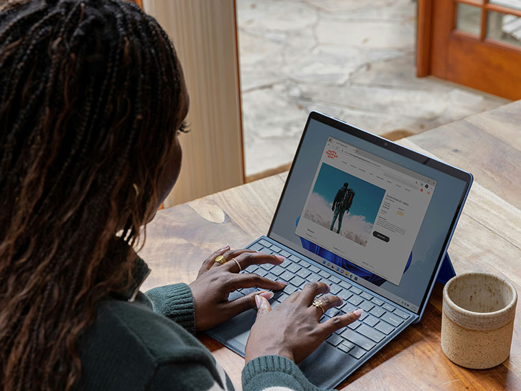 Someone sat at a desk working on a laptop at home