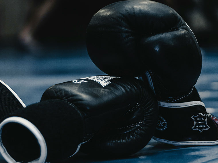 A pair of black boxing gloves, one laid on it's side