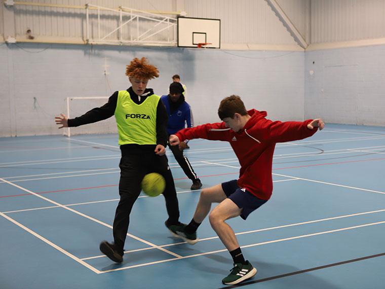 Students playing football in the sports hall at Dearne Valley College