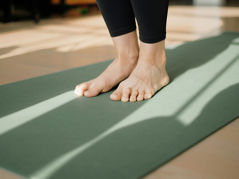 Close up of someone's bare feet on a yoga mat